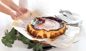 Tarta quemada, lista tras su tiempo de cocción, decorada con frutos rojos y espolvoreada con azúcar glas.