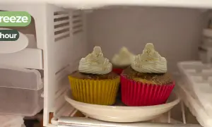 Dos magdalenas con glaseado blanco y canela, en sus envoltorios amarillo y rosa, están en el congelador. ¡Las magdalenas se pueden congelar!