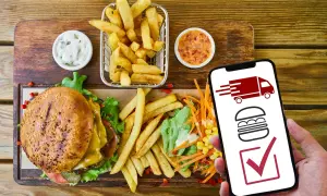 Hamburguesa, papas fritas y ensalada. El móvil muestra un camión de reparto y una hamburguesa, indicando que es rentable un negocio de comida para llevar.