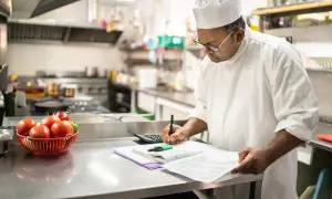 Chef calculando el coste de los ingredientes, un ejemplo de que es un escandallo en cocina.