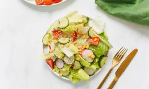 Ensalada fresca con fresas, pepino, rábano y maíz, perfecta para negocios de comida saludable. Cubierta con semillas de sésamo.
