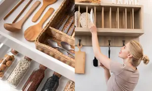 Organización en el departamento de cocina: cajón con utensilios de madera y cestas, y estante de madera con platos y una mujer.