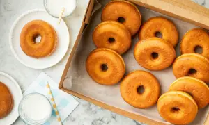 Una caja llena de deliciosos donuts dorados, perfectos para disfrutar o para saber que se pueden congelar los donuts y tenerlos listos para más tarde.