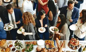 Gente disfrutando de la comida de personal en restaurantes, con una mesa llena de ensaladas, mariscos, frutas y pan.