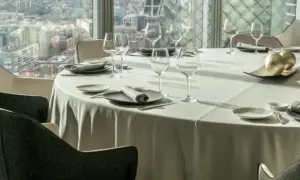 Mesa elegante en un restaurante con vistas a la ciudad, ideal para disfrutar de los mejores restaurantes de España.