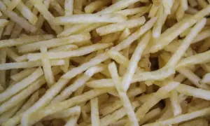 Patatas cortadas finas, listas para freír. Aprende como cortar patatas paja para un aperitivo crujiente.