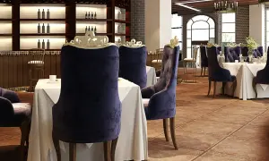 Elegantes sillas de terciopelo púrpura y mesas vestidas esperan a los comensales en este restaurante. El ambiente evoca nombres de restaurantes elegantes.