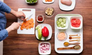 Mise en place restaurante: zanahorias cortadas, lechuga, pimiento rojo, pepino, tomate, pollo y condimentos listos para cocinar.
