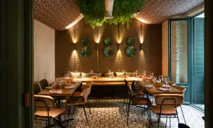 Elegante diseño de iluminación en restaurantes, con mesas puestas y vegetación colgante.