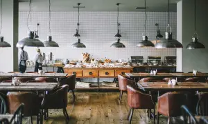 Mesas y sillas de cuero en un restaurante con un buffet. Se aprecian varias partes de un restaurante, como la zona de servicio y el comedor.