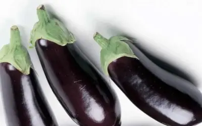 Tres berenjenas oscuras listas para aprender como quitar el amargor a las berenjenas y disfrutar de su sabor.