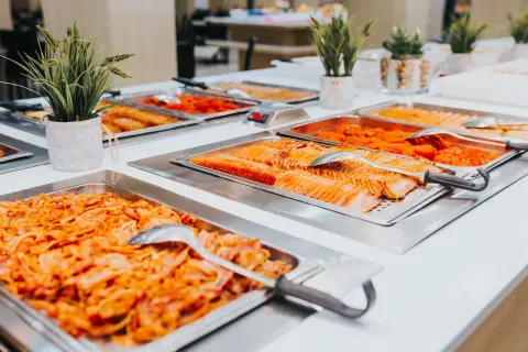 Bandejas de salmón y otros platos de quinta gama en un buffet.