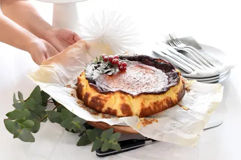 Tarta quemada, lista tras su tiempo de cocción, decorada con frutos rojos y espolvoreada con azúcar glas.