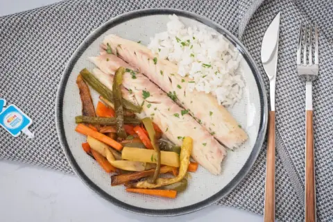 Lubina al horno con verduras y arroz. Descubre el tiempo y temperatura perfectos para esta receta saludable.