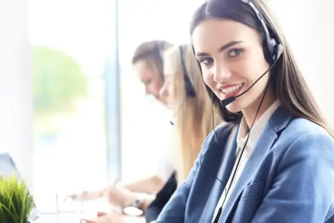 Sonriente personal de sala con auriculares, lista para atenderte.