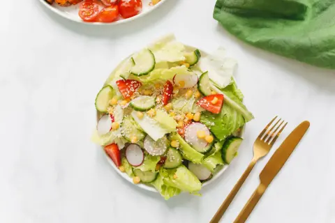 Ensalada fresca con fresas, pepino, rábano y maíz, perfecta para negocios de comida saludable. Cubierta con semillas de sésamo.