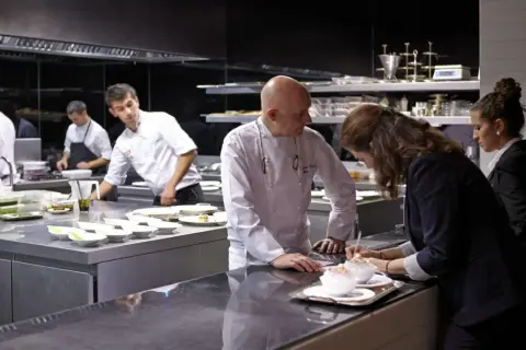 Chefs en cocina profesional preparan platos para conseguir una estrella Michelin.