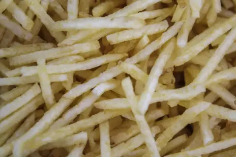 Patatas cortadas finas, listas para freír. Aprende como cortar patatas paja para un aperitivo crujiente.