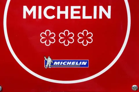 Placa roja Michelin con tres estrellas, símbolo de un chef con mas estrellas michelin.