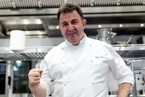 Chef Martín Berasategui, sonriendo y mostrando su puño, en su cocina. ¿Cuántas estrellas Michelin tiene Martín Berasategui?