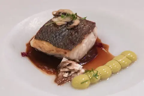 Delicioso filete de lubina a baja temperatura, con champiñones y una guarnición de puré verde.