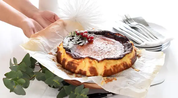 Tarta quemada, lista tras su tiempo de cocción, decorada con frutos rojos y espolvoreada con azúcar glas.