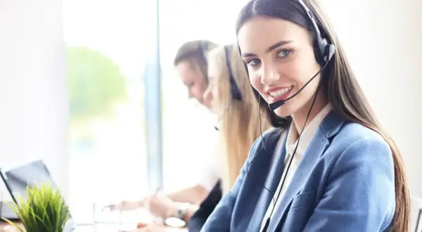 Sonriente personal de sala con auriculares, lista para atenderte.