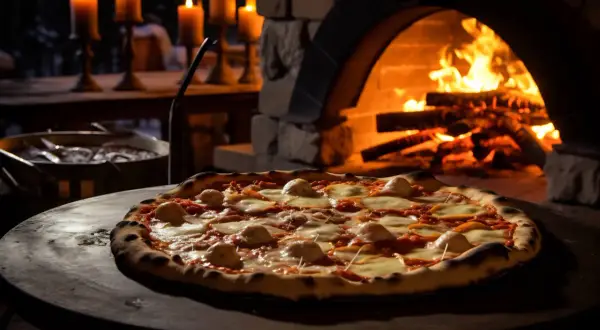 Pizza recién hecha, lista para disfrutar. El horno de leña, con su fuego crepitante, garantiza la temperatura y el tiempo perfectos para una masa crujiente y un queso fundido.