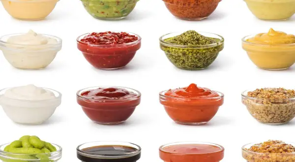 Variedad de salsas y aderezos en cuencos de cristal. Ingredientes clave para emulsionantes naturales en la cocina, como mayonesa, guacamole y mostaza.