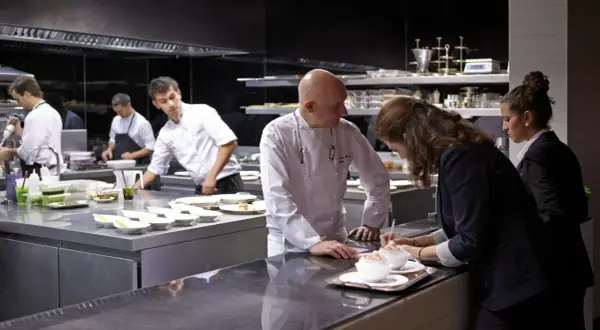 Chefs en cocina profesional preparan platos para conseguir una estrella Michelin.