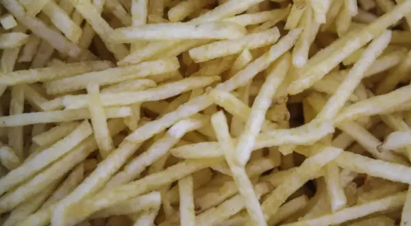 Patatas cortadas finas, listas para freír. Aprende como cortar patatas paja para un aperitivo crujiente.