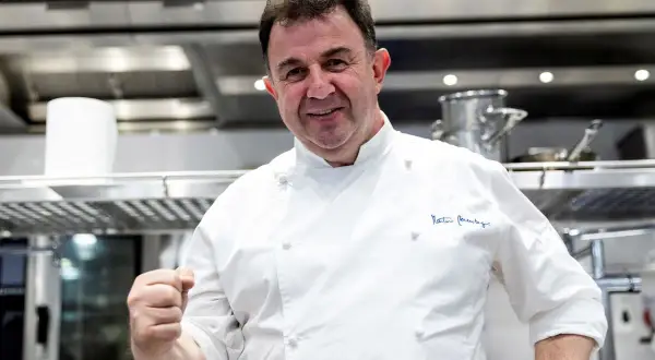 Chef Martín Berasategui, sonriendo y mostrando su puño, en su cocina. ¿Cuántas estrellas Michelin tiene Martín Berasategui?