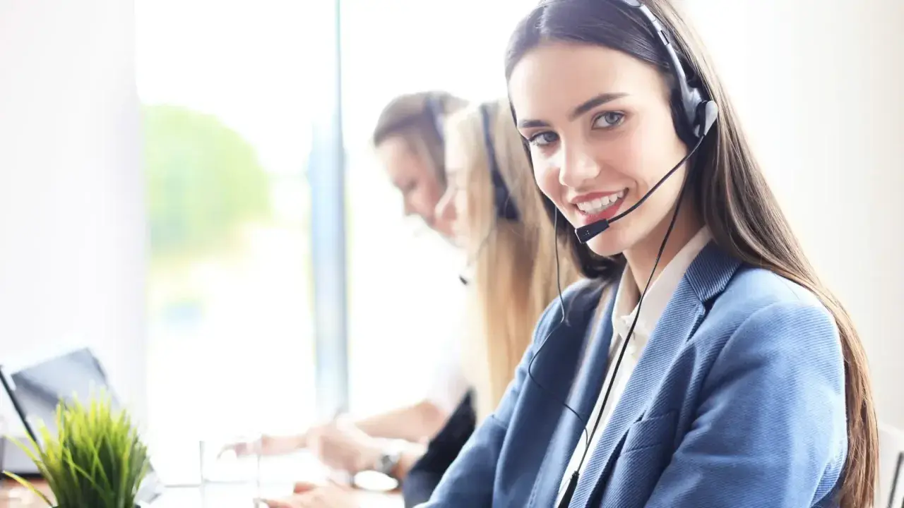Sonriente personal de sala con auriculares, lista para atenderte.