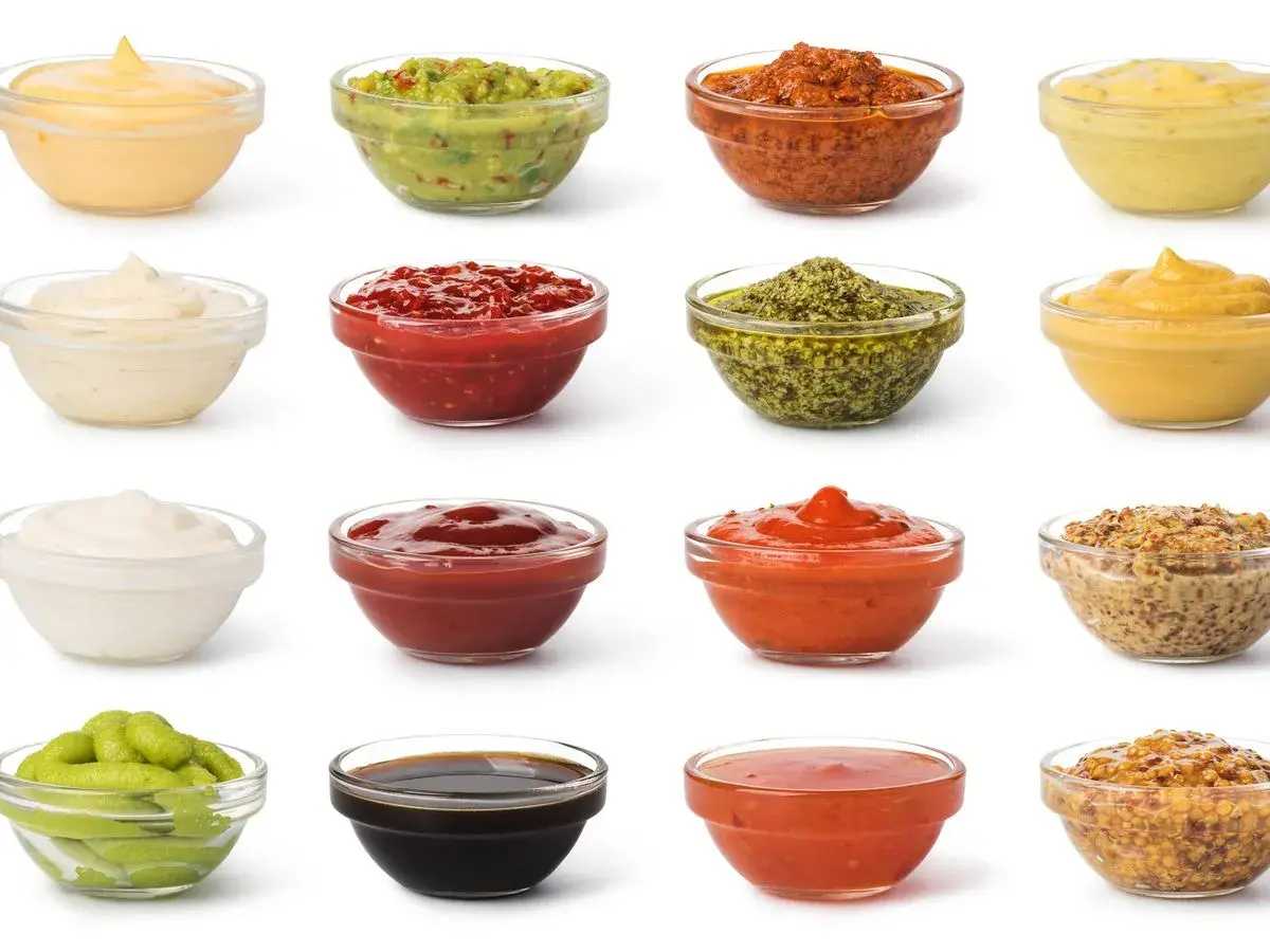 Variedad de salsas y aderezos en cuencos de cristal. Ingredientes clave para emulsionantes naturales en la cocina, como mayonesa, guacamole y mostaza.