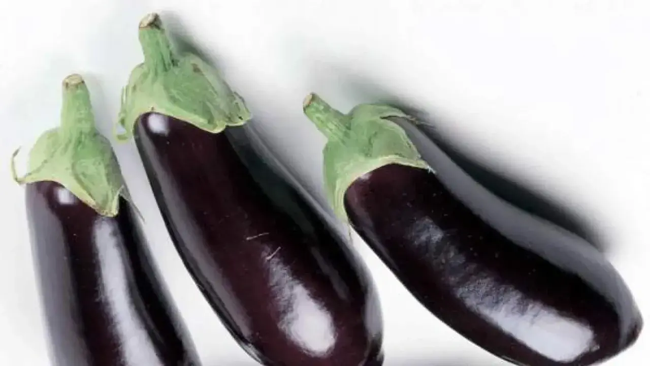 Tres berenjenas oscuras listas para aprender como quitar el amargor a las berenjenas y disfrutar de su sabor.
