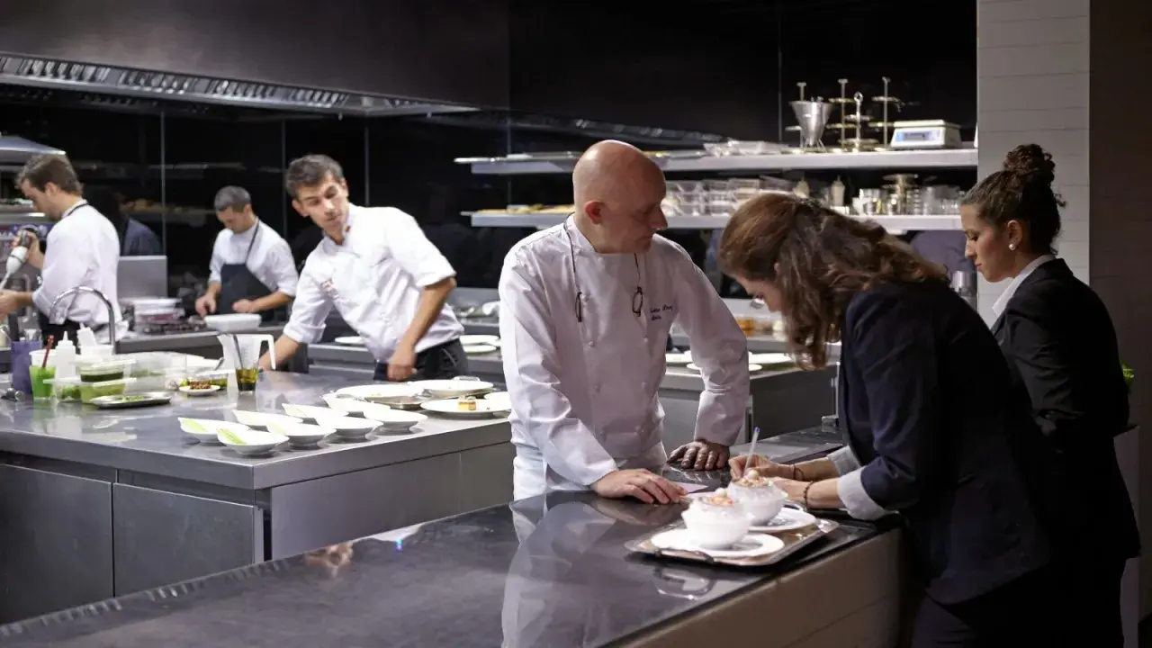 Chefs en cocina profesional preparan platos para conseguir una estrella Michelin.