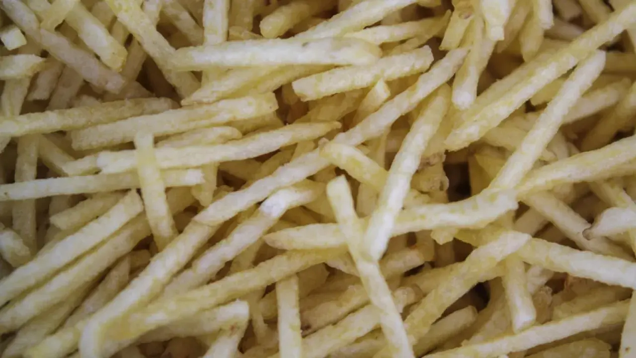 Patatas cortadas finas, listas para freír. Aprende como cortar patatas paja para un aperitivo crujiente.