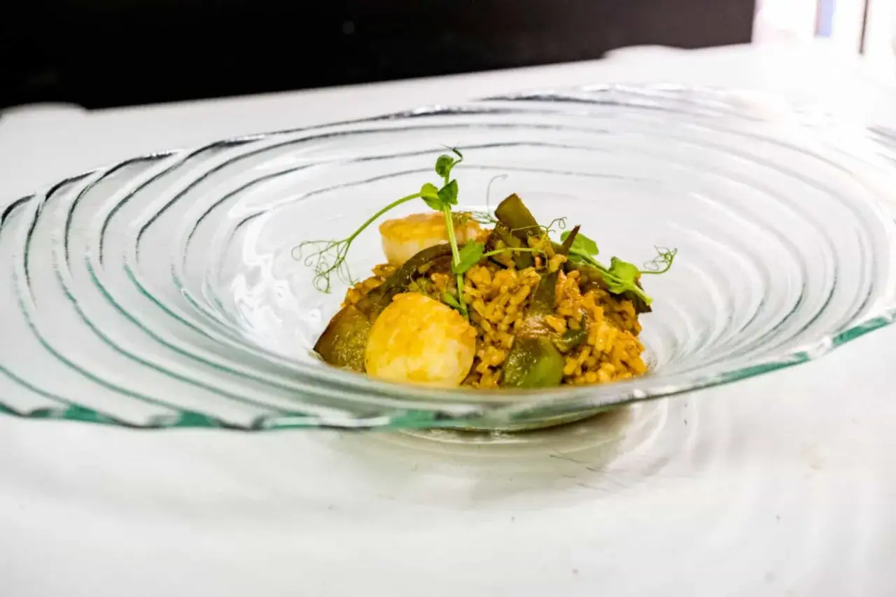 Arroz con verduras y vieiras, un plato que evoca la esencia de un curso de cocina mediterr&aacute;nea.