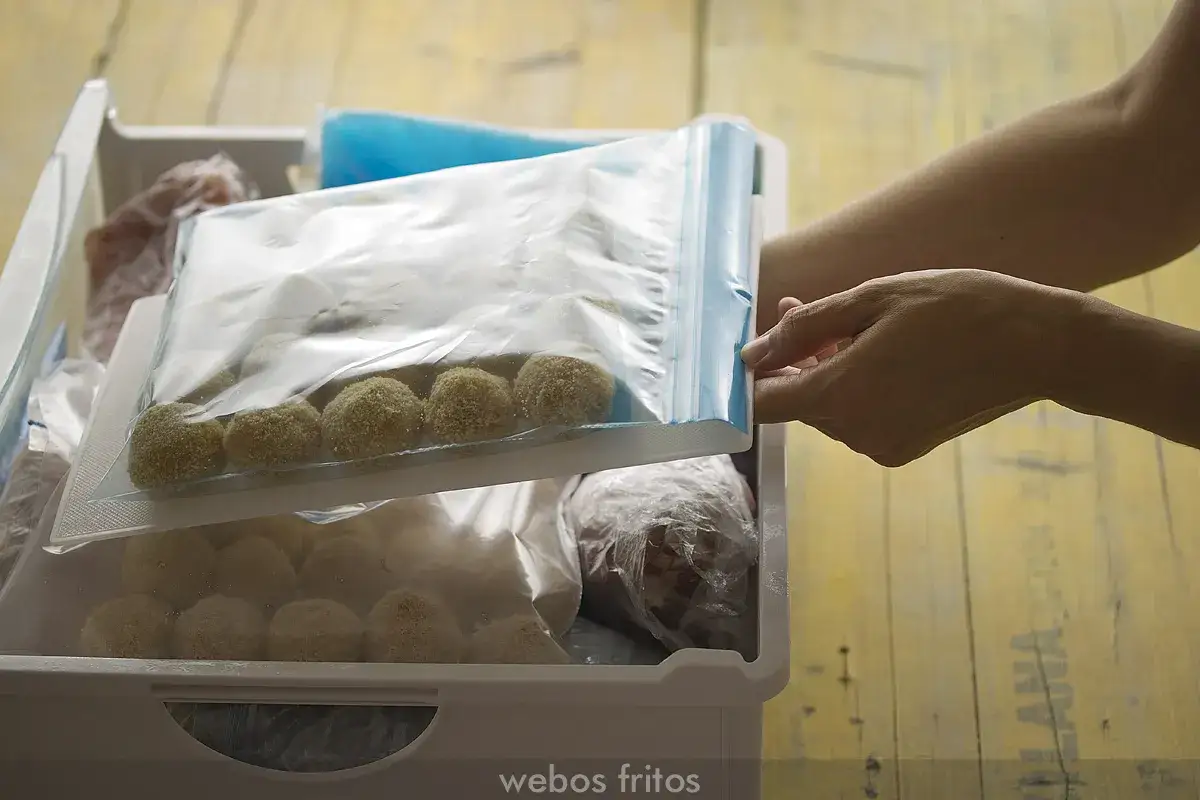 Manos cierran bolsa con masa de croquetas para que se pueda congelar la masa de croquetas.