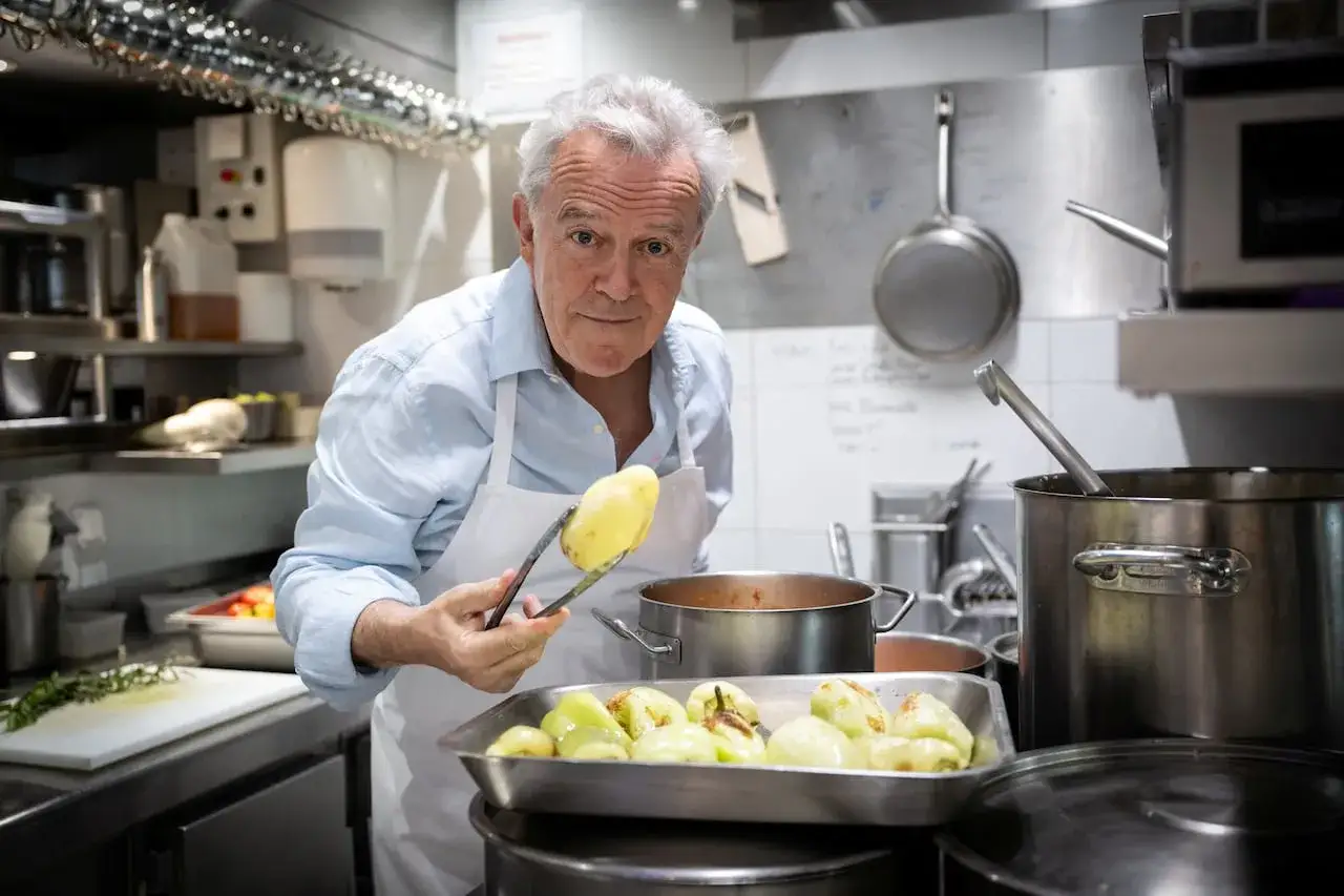 Jean Imbert, chef, con patatas en pinzas en una cocina profesional.