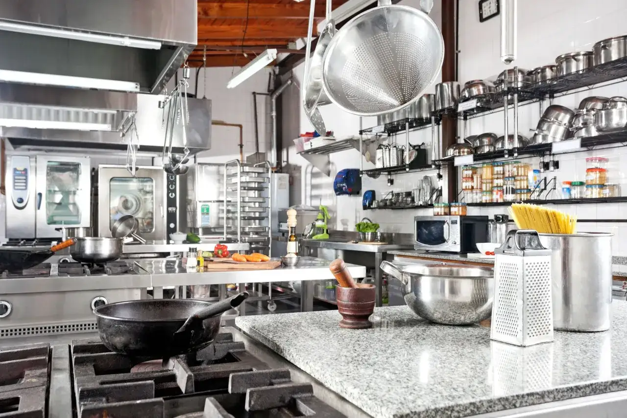 Cocina profesional lista para la acci&oacute;n: ollas, sartenes, verduras y pasta, todo en su sitio. Mise en place restaurante.