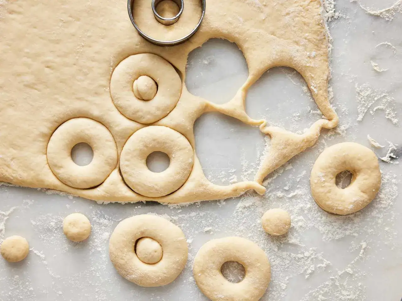 Masa de donuts reci&eacute;n cortada, lista para fre&iacute;r o para que se puedan congelar los donuts y disfrutar m&aacute;s tarde.
