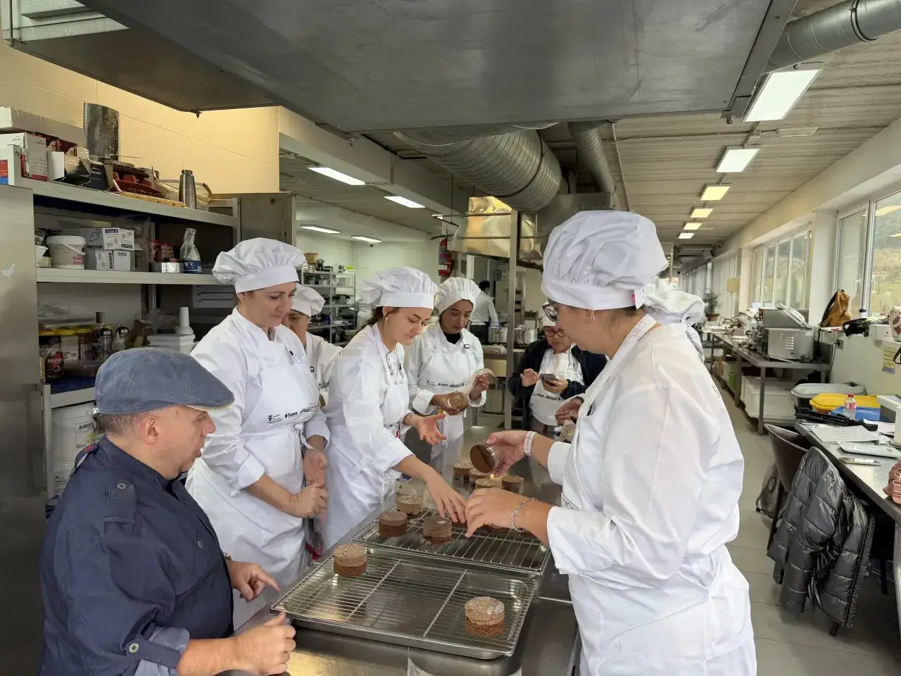 Estudiantes en una clase de repostería decoran pasteles.