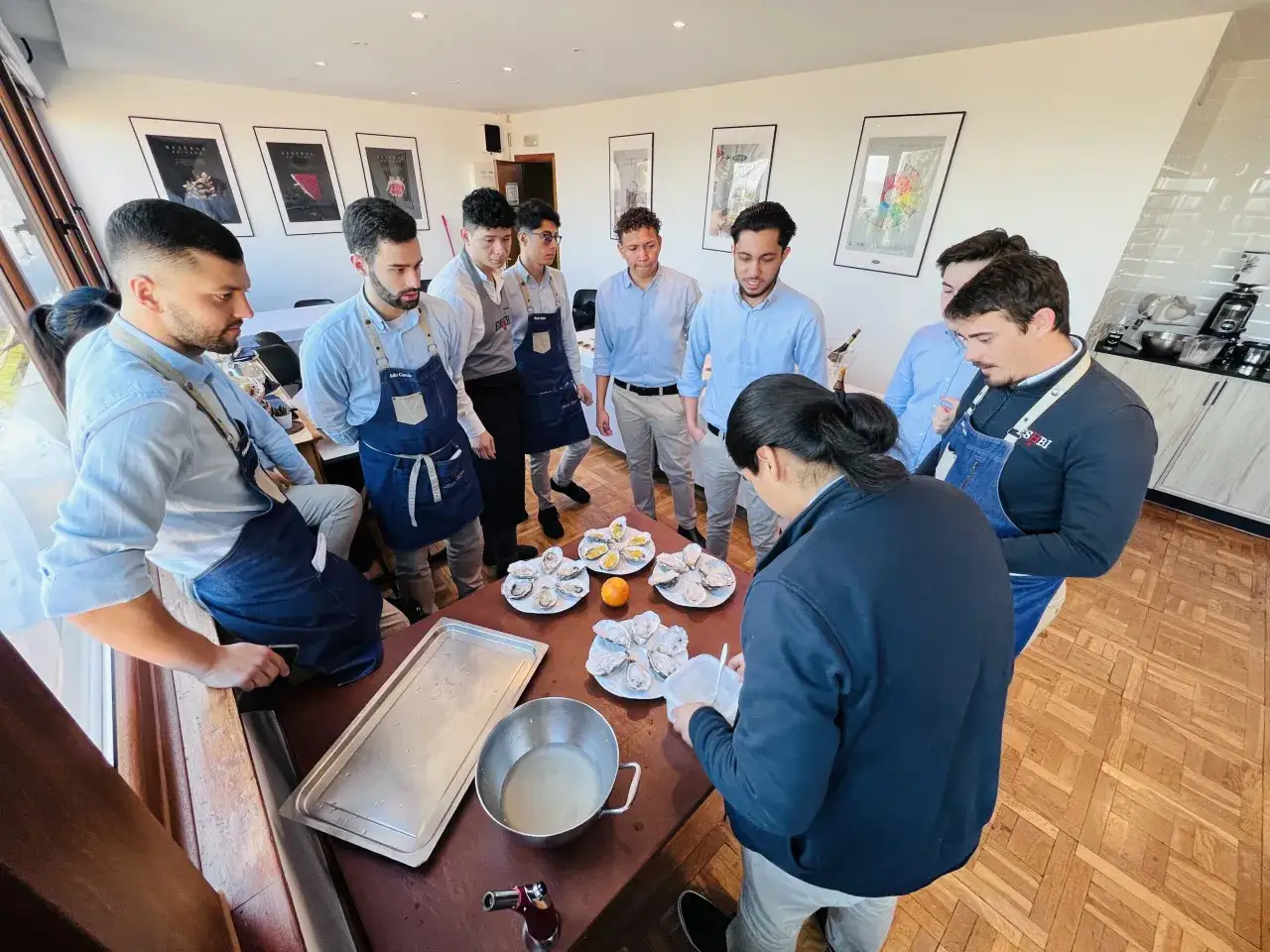 Estudiantes aprenden el master direccion restauracion abriendo ostras.