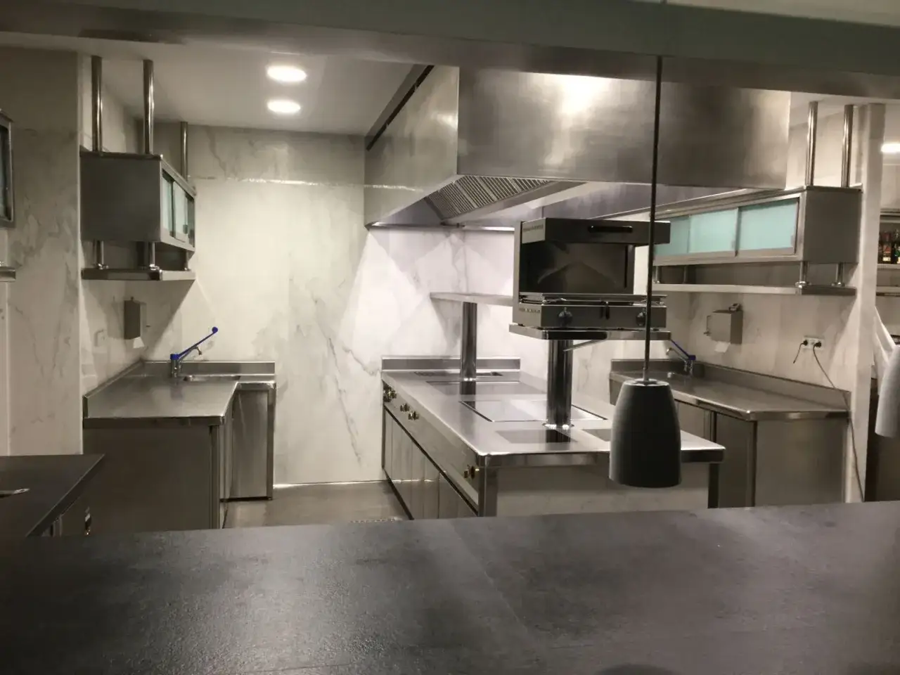 Cocina profesional de acero inoxidable, lista para el food service. Equipamiento moderno y superficies impecables.