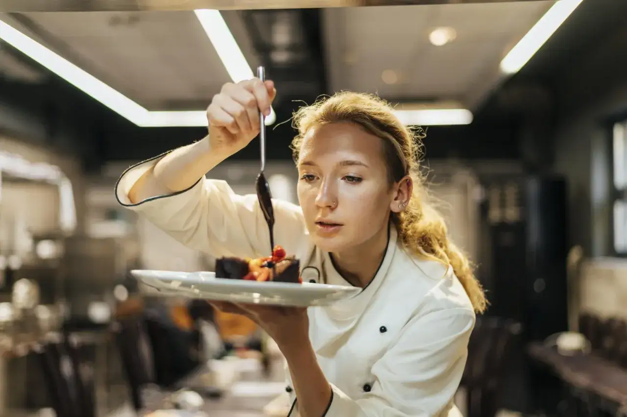 Chef decora un pastel con chocolate, mostrando sus habilidades culinarias.