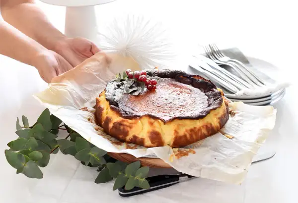 Tarta quemada, lista tras su tiempo de cocción, decorada con frutos rojos y espolvoreada con azúcar glas.