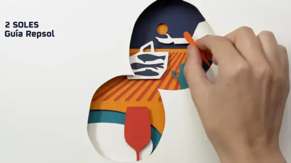 Guía Repsol: cómo conseguir un solete. Mano colocando piezas de papel recortado: cesta con peces, copa y sol.