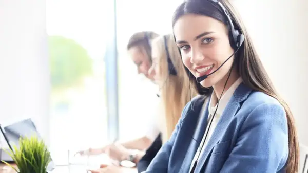 Sonriente personal de sala con auriculares, lista para atenderte.