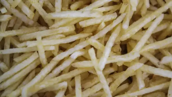 Patatas cortadas finas, listas para freír. Aprende como cortar patatas paja para un aperitivo crujiente.